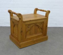 A pine window seat with lift up top and gothic carved front panels, 67 x 61 x 43cm.