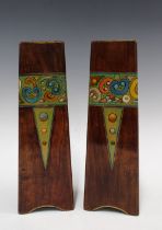 A pair of Art Nouveau wooden vases, triangular form and painted with a band of stylised flowers,
