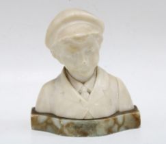 Early 20th century hardstone head and shoulders bust of a young boy in a flat cap, 13 x 14cm