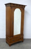 An Arts & Crafts style oak mirror door wardrobe, 108 x 212 x 57cm.