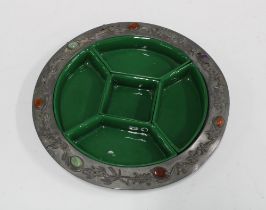 An early 20th century pewter dish with set of five green glazed pottery serving dishes, 26cm