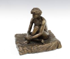 Bronze figure of a female nude, modelled seated on a square base, 28cm