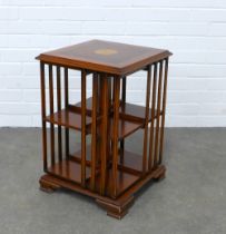 Yew wood revolving bookcase, the square top with an inlaid paterae, 40 x 60cm.