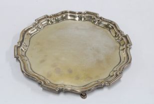 George V silver salver, circular with pie crust border and three hoof feet, Mappin & Webb, Sheffield