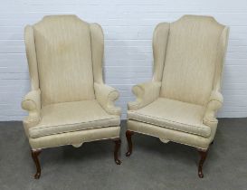 Pair of cream upholstered wing back armchairs, on cabriole legs, 85 x 128 x 54cm. (2)