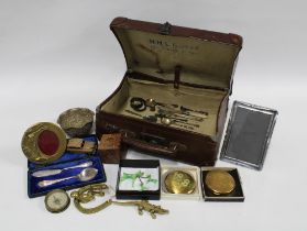 Small leather travel case containing vintage powder compacts, small compass, brass photo frame,
