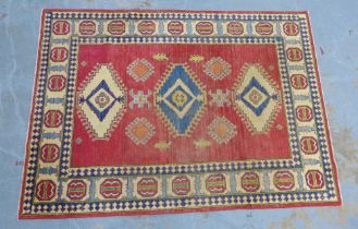 Yakash large wool Kazak rug, red field with three serrated edge medallions within multiple