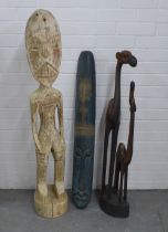An African carved wooden mask, camel figure group and a carved floor standing male figure, 123cm
