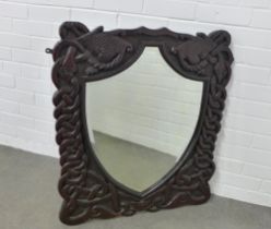 Arts & Crafts dark oak wall mirror with shield shaped plate within a carved knotwork frame, 73 x
