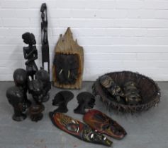 A quantity lot of wooden face masks, carved African figures and a basket, etc