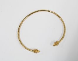 A gold cuff bangle with foliate engraved pattern, stamped 14k