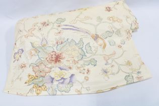 Roll of pale yellow floral fabric.