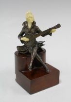 An Art Deco style bronze and faux ivory figure of a female minstrel banjo player, on a stepped