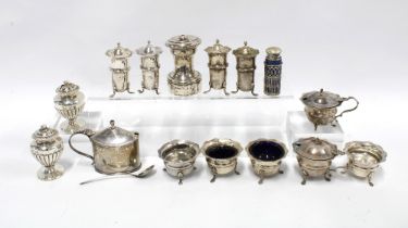 A collection of silver condiments to include salts, peppers and mustards, mixed makes and