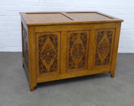 An Arts & Crafts carved oak blanket chest with lift up top, the front with Tudor Roses and