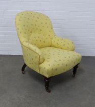 Early 20th century armchair with yellow floral upholstery, on turned legs with brass castors, insid