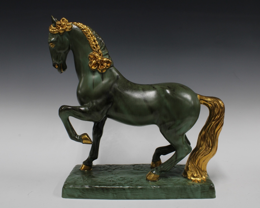 Green and gilt glazed horse on a rectangular plinth base, (small glaze nick to tip of one ear) 42