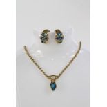 14ct gold pendant necklace set with a pear shaped blue topaz and a round brilliant cut diamond