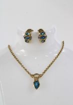 14ct gold pendant necklace set with a pear shaped blue topaz and a round brilliant cut diamond