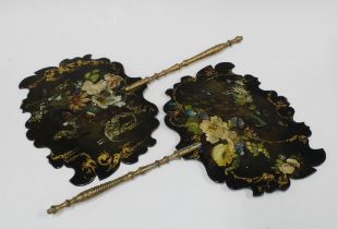 A pair of 19th century black lacquered papier mache face screens, each painted with flowers gilt