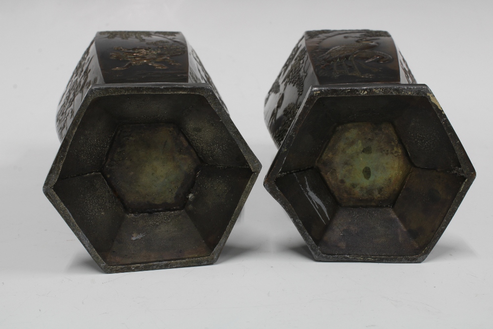 A pair of Japanese bronze patinated metal vases, hexagonal form with relief pattern of storks and - Image 3 of 3