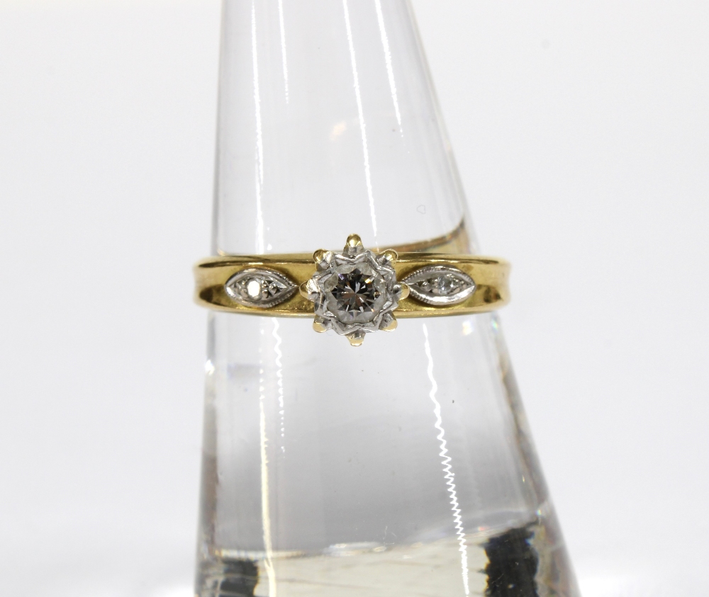 18ct gold ring with a claw set diamond in a high platinum setting flanked by a diamond to each