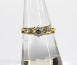 18ct gold ring with a claw set diamond in a high platinum setting flanked by a diamond to each