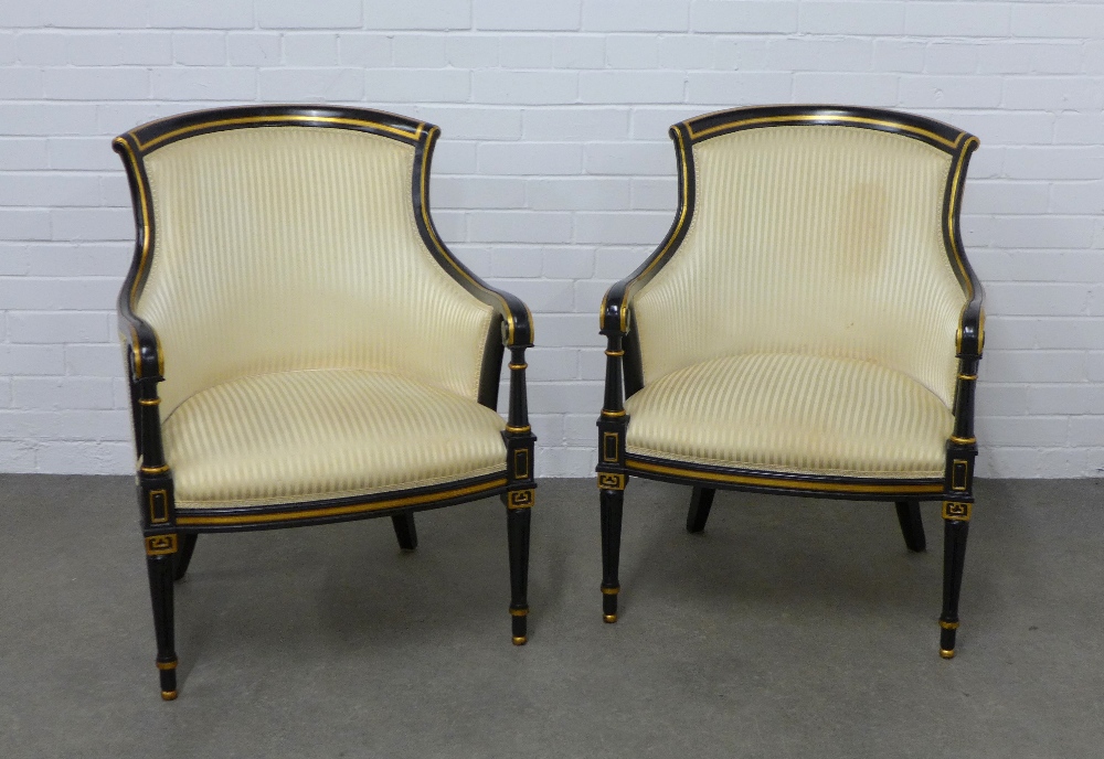 Pair of ebonised and parcel gilt open armchairs, with striped damask upholstery, on tapering legs,