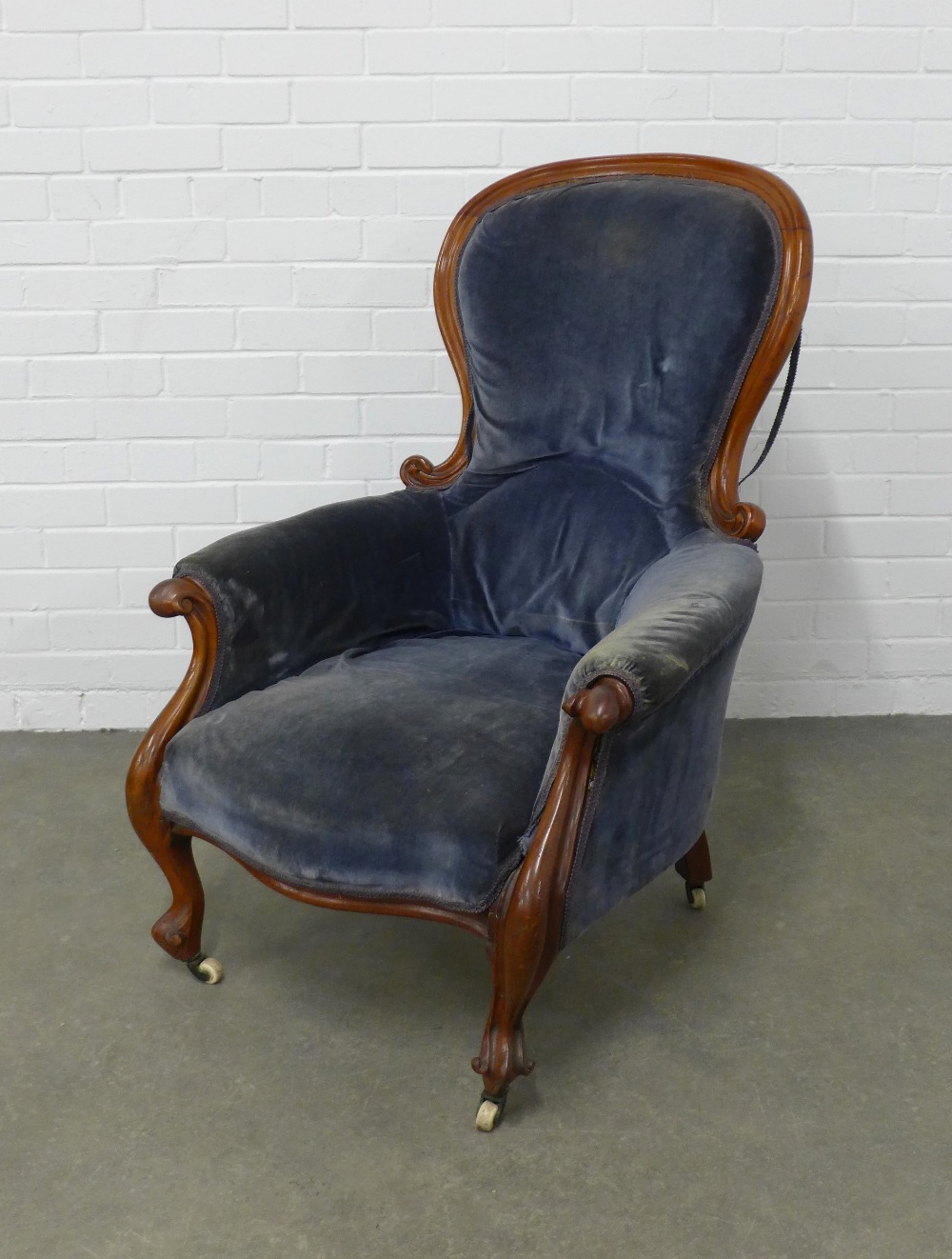 Victorian mahogany framed spoonback armchair with blue upholstery, raised on cabriole legs and