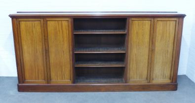 Mahogany bookcase, central shelved section flanked by cupboard doors, on a plinth base, 276 x 130