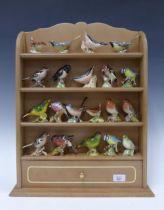 A collection of 20 Beswick pottery bird figures together with a shelved wall display rack