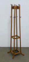 An early 20th century oak hat and coat stand, freestanding with original metal hooks and drip pan,