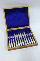 Set of six mother of pearl and Epns fruit knives and forks in a mahogany canteen box, 30 x 25cm.