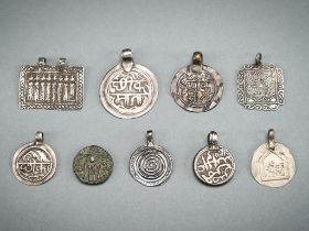 A FINE LOT WITH NINE SILVER AND METAL REPOUSSE AMULETS, c. 1900s