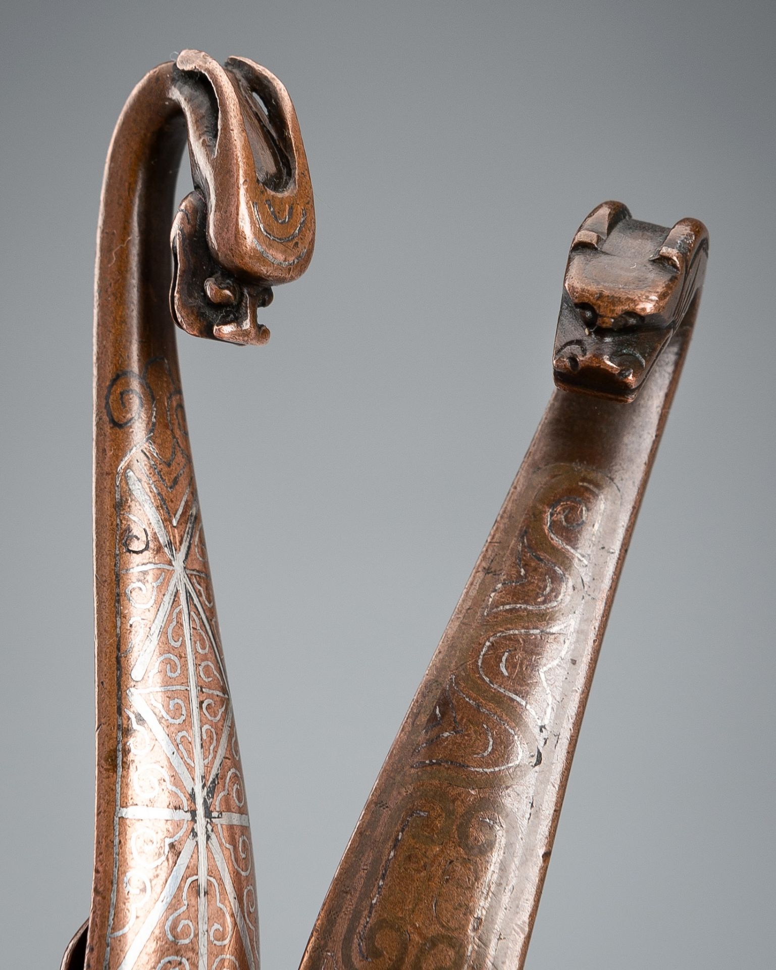A GROUP OF TWO SILVER-INLAID BRONZE BELT HOOKS, 17TH CENTURY