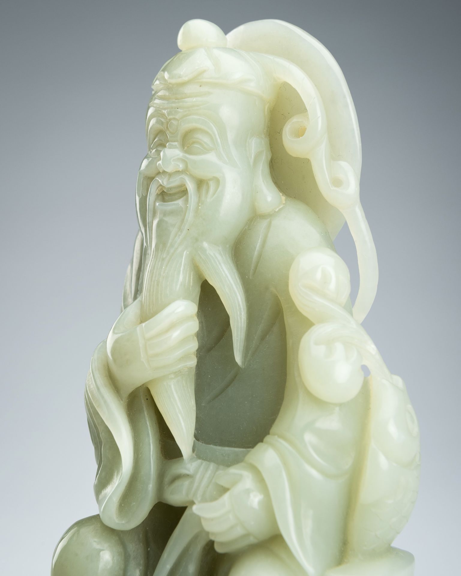 A JADE FIGURE OF AN IMMORTAL WITH FISH, LATE QING DYNASTY