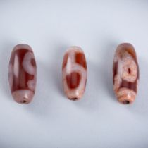 A GROUP OF THREE CARNELIAN DZI BEADS, 18TH CENTURY OR EARLIER