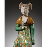 A RARE SANCAI-GLAZED POTTERY FIGURE OF A SEATED COURT LADY, TANG DYNASTY OR LATER