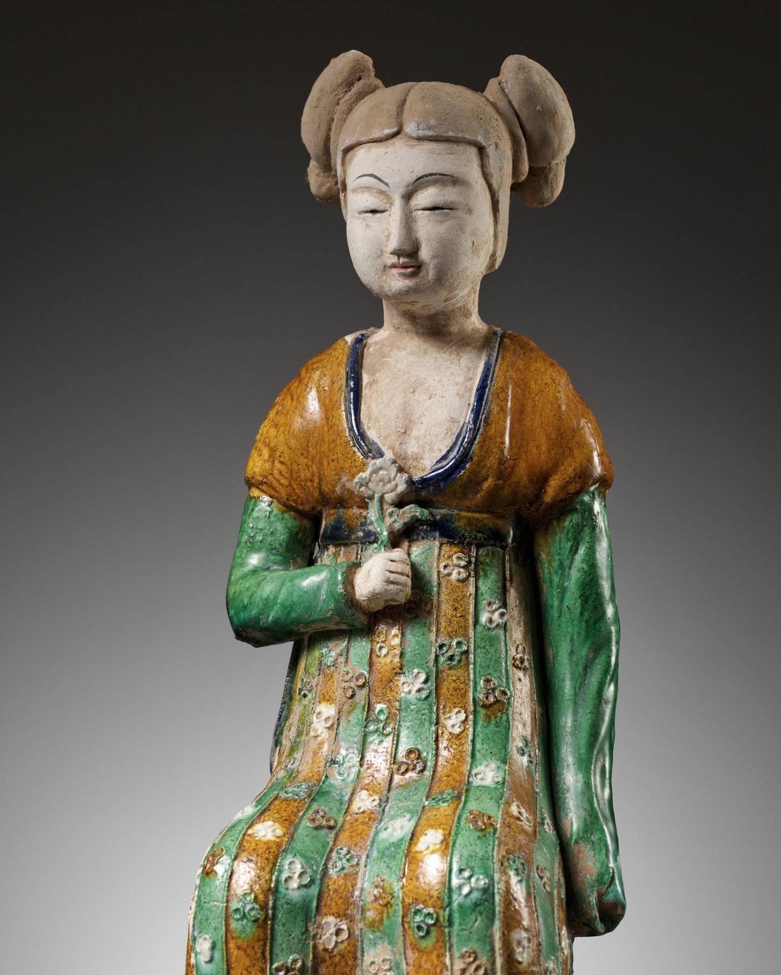 A RARE SANCAI-GLAZED POTTERY FIGURE OF A SEATED COURT LADY, TANG DYNASTY OR LATER