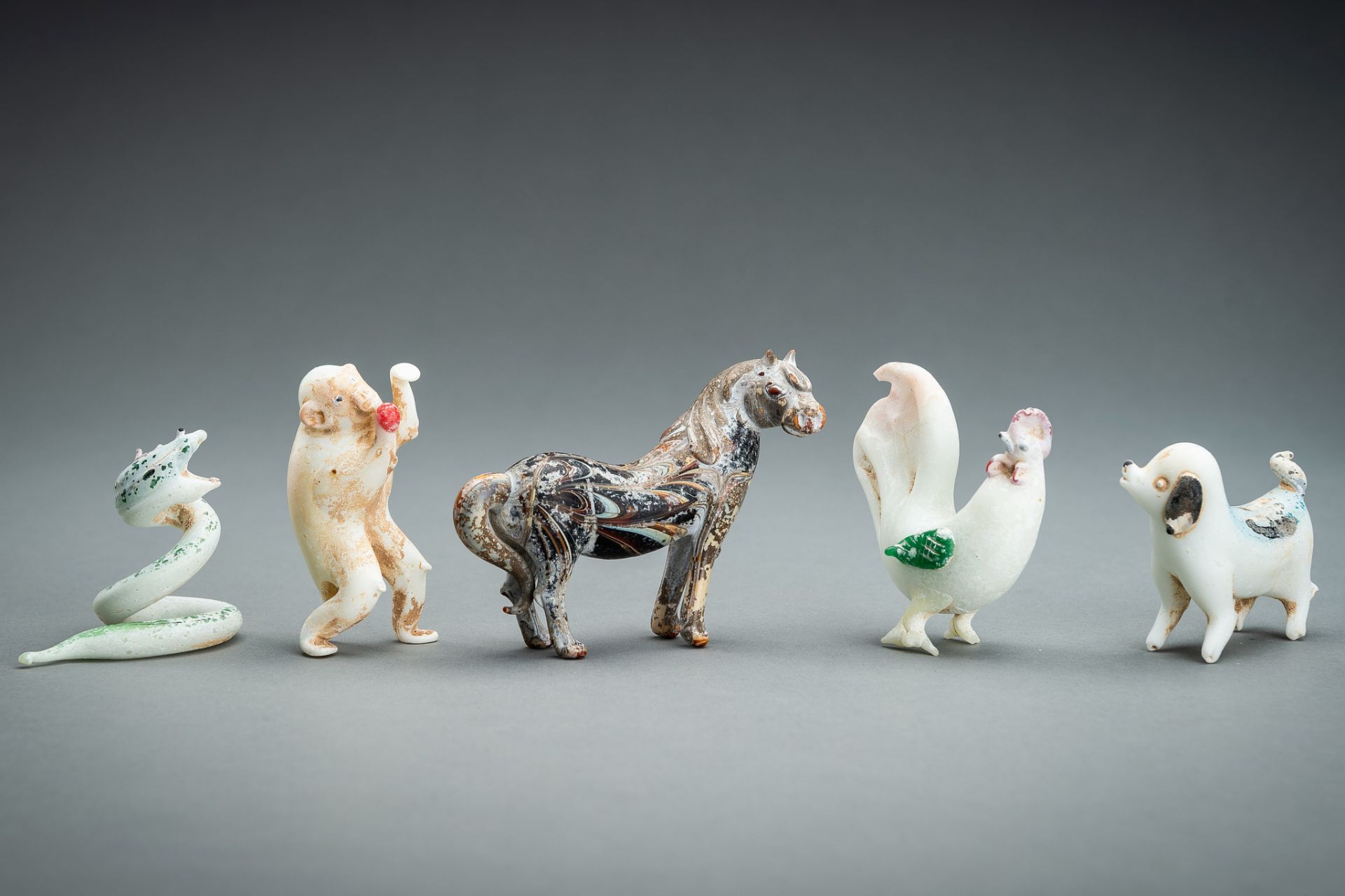 A RARE GROUP OF FIVE 'ZODIAC' GLASS FIGURES, QING DYNASTY OR EARLIER