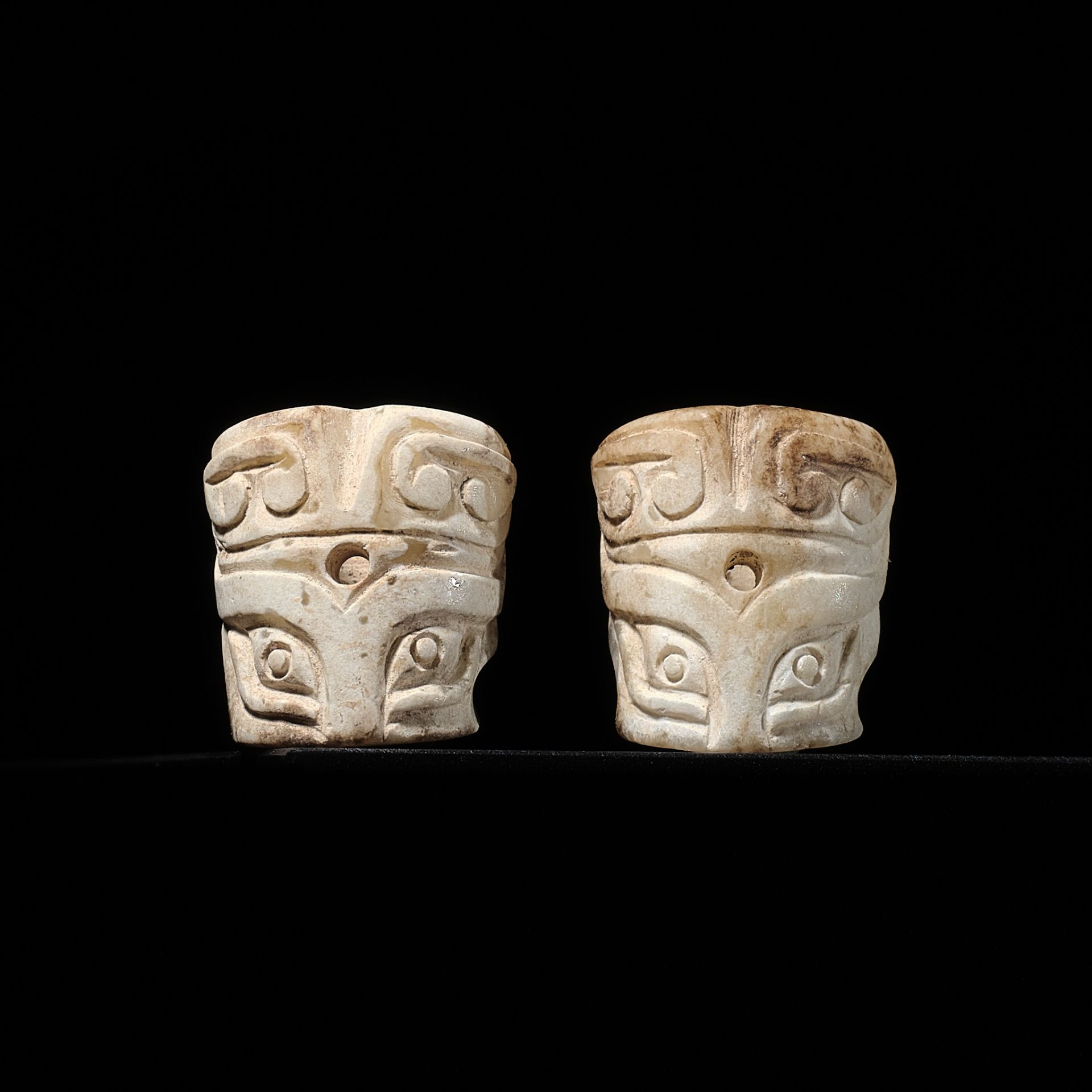 A PAIR OF CYLINDRICAL 'TAOTIE MASK' JADE BEADS, SHANG DYNASTY