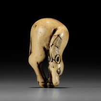 A SUPERB ANTLER NETSUKE OF A GRAZING HORSE, ATTRIBUTED TO TSUNEMASA