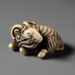 A FINE MARINE IVORY NETSUKE OF A RECLINING GOAT