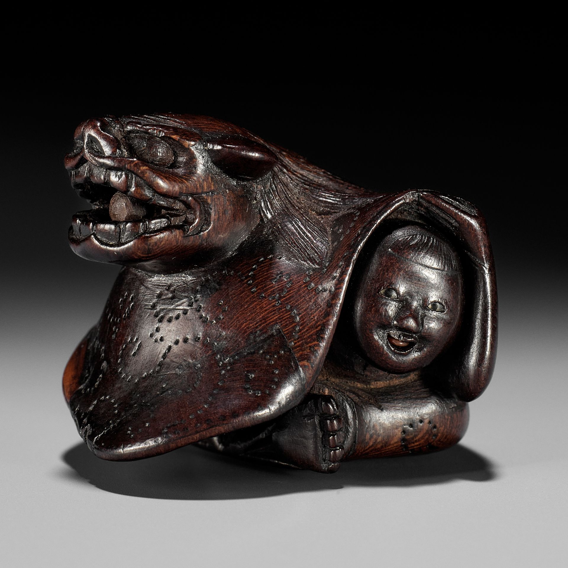 MIWA: A FINE WOOD NETSUKE OF A BOY AT SHISHIMAI