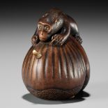 MASAHIRO: A FINE INLAID WOOD NETSUKE OF A MONKEY ON A PAIR OF CHESTNUTS