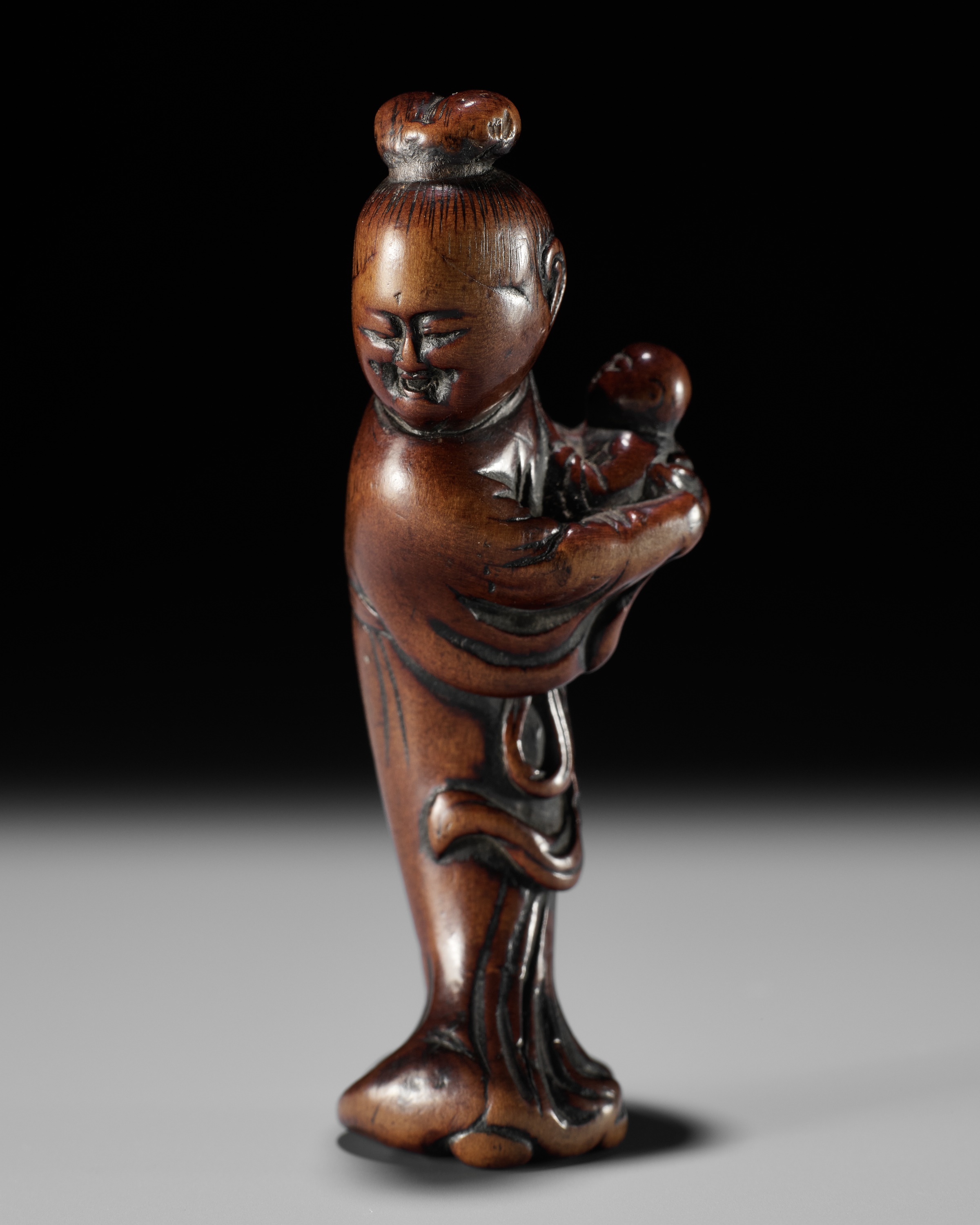 A WOOD NETSUKE OF KAKKYO'S WIFE AND CHILD