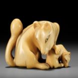 A RARE IVORY NETSUKE OF A KITSUNE (FOX) AND CUB