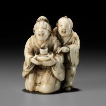 A RARE IVORY NETSUKE OF A BLINDFOLDED GEISHA WITH ATTENDANT