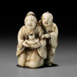 A RARE IVORY NETSUKE OF A BLINDFOLDED GEISHA WITH ATTENDANT