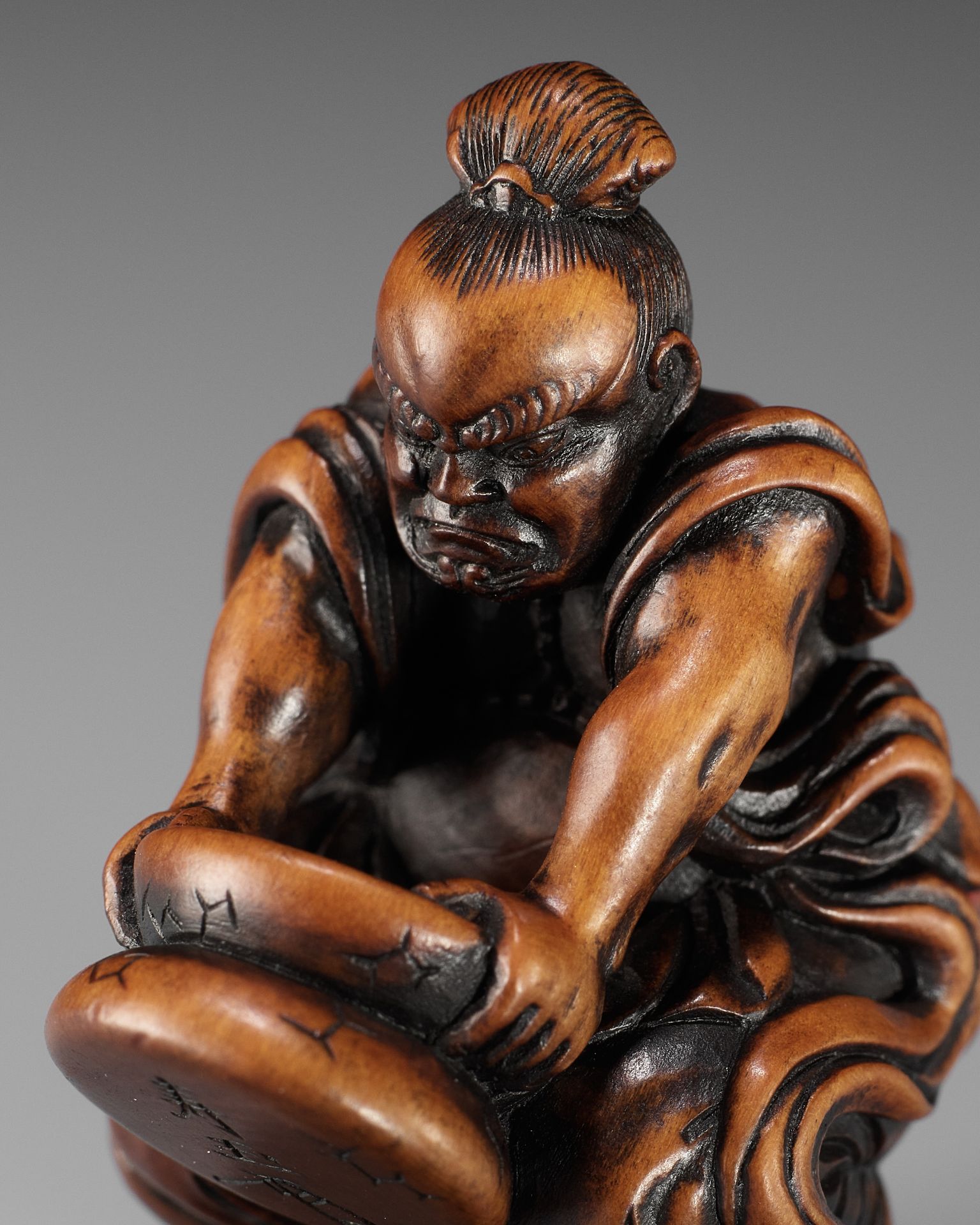 JUGYOKU: A POWERFUL WOOD NETSUKE OF A NIO CRUSHING MOCHI